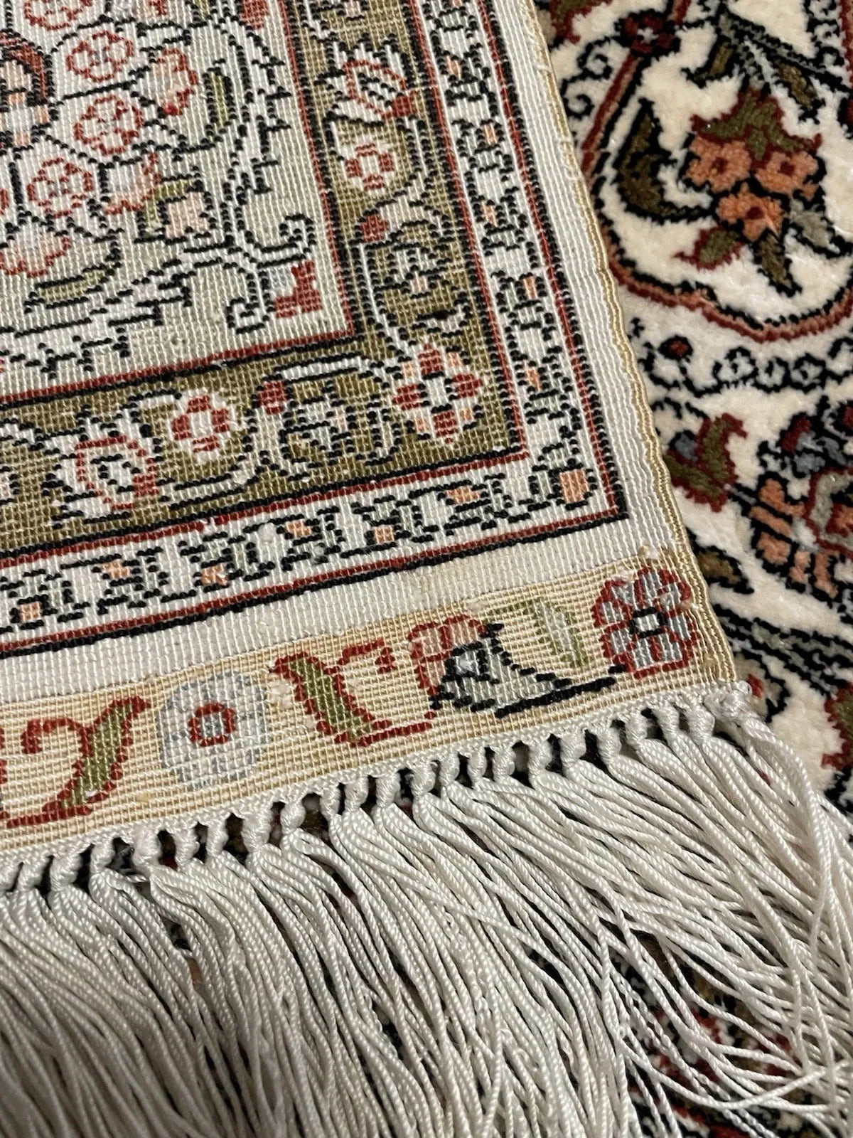 Antique-style Turkish Hereke silk prayer rug in good to very good condition, with even lustrous pile, intact ivory silk fringe, sound selvedges, and a woven workshop cartouche in the lower border.


