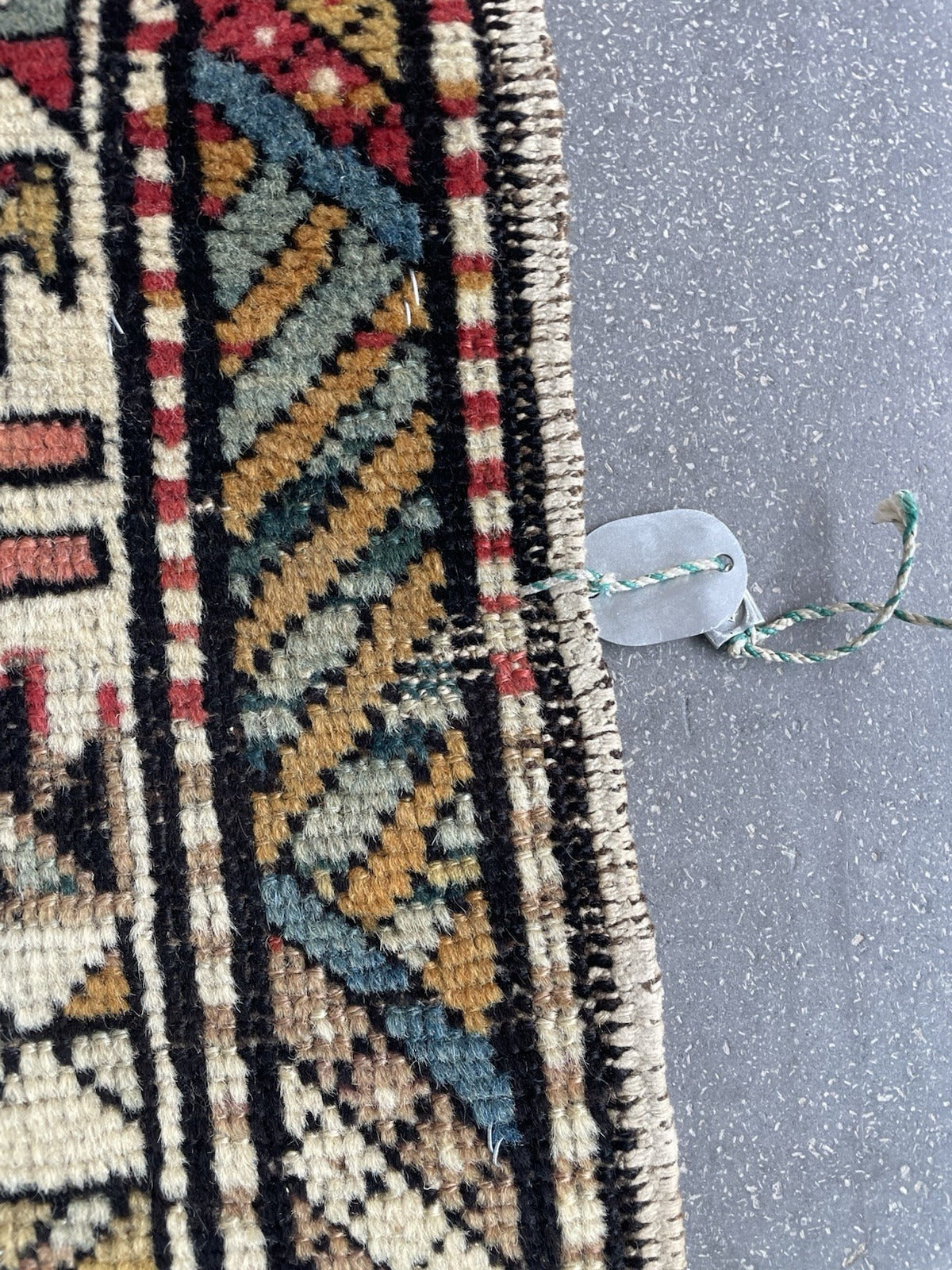 Close-up of the terminal end of an antique Shirvan rug, showing significant pile loss, exposed foundation threads, and severely worn partially missing fringe – condition issues fully disclosed and reflected in price.

