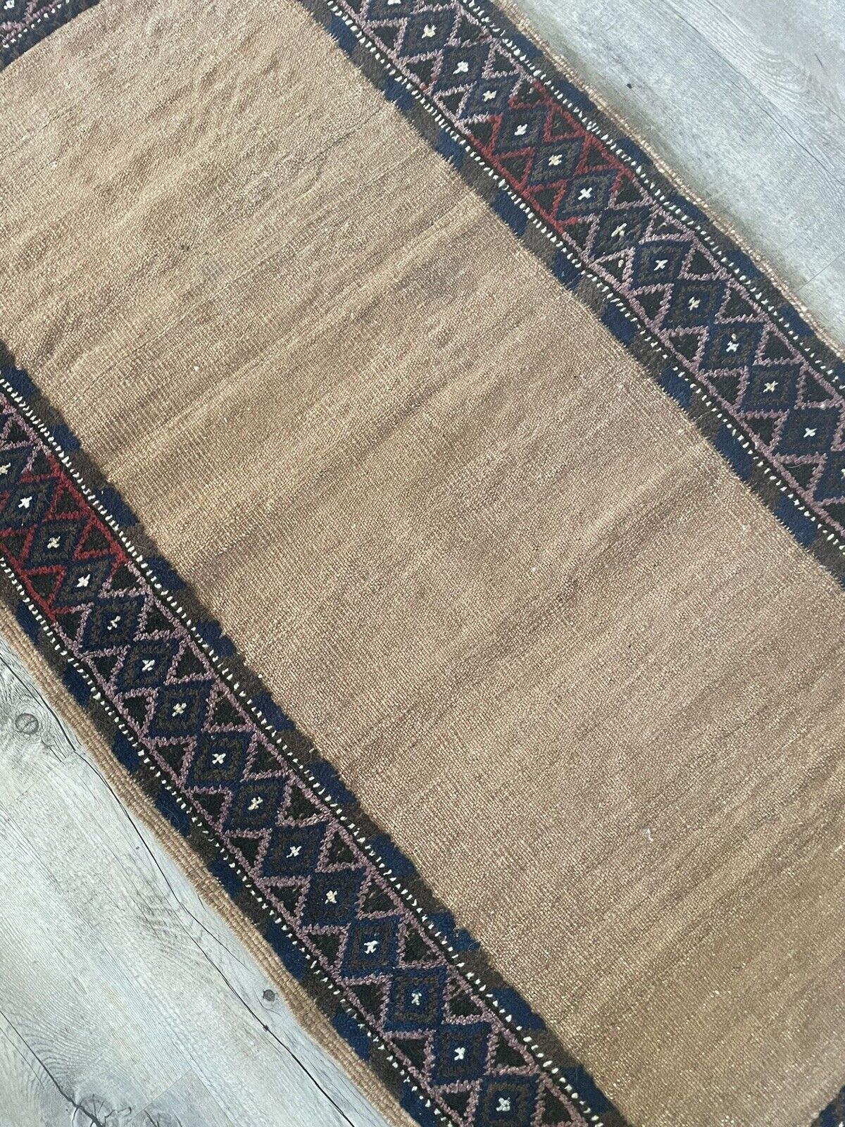 Close-up of geometric patterns on Handmade Antique Afghan Baluch Collectible Rug - Detailed view showcasing the intricate geometric patterns adorning the sides of the rug, created through pile weaving.