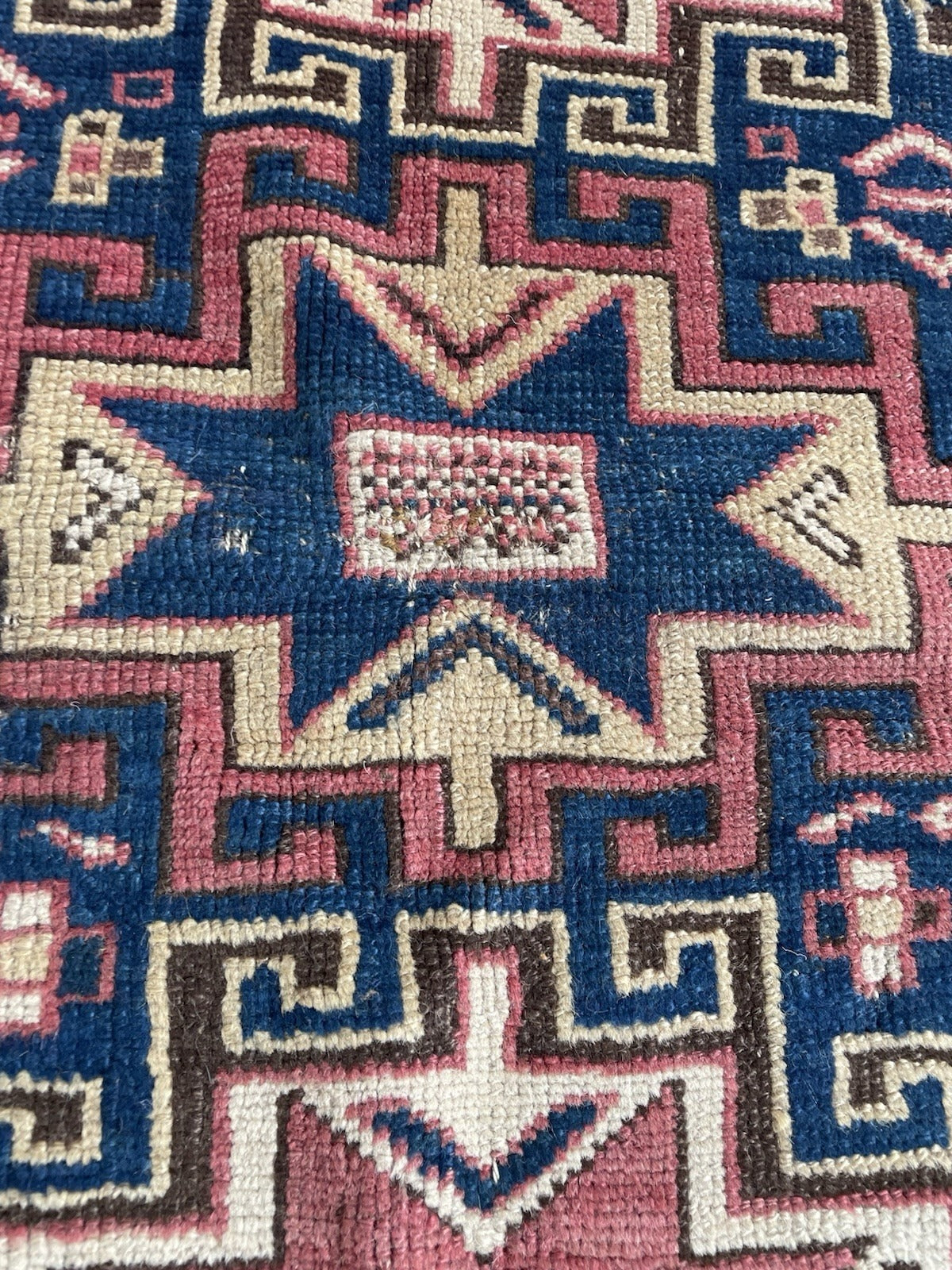 Full view of a circa 1880 Kazak rug in good to very good condition for its 140-year age, with strong unfaded natural dye colors including royal blue indigo, madder rose, dark brown-black, and undyed ivory.

