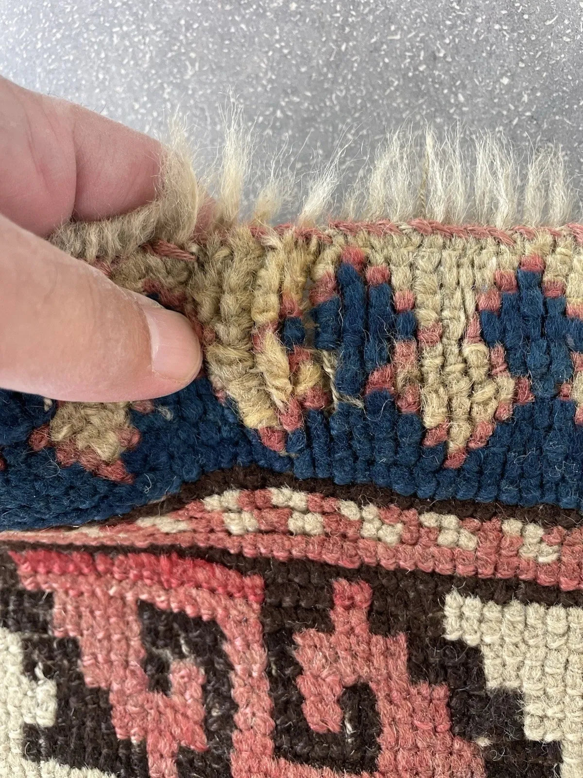 Full view of a well-preserved antique Kazak rug with intact blue-purple overcast selvedges, intact kilim bands at ends, and long, loosely twisted fringe with no significant breakage.

