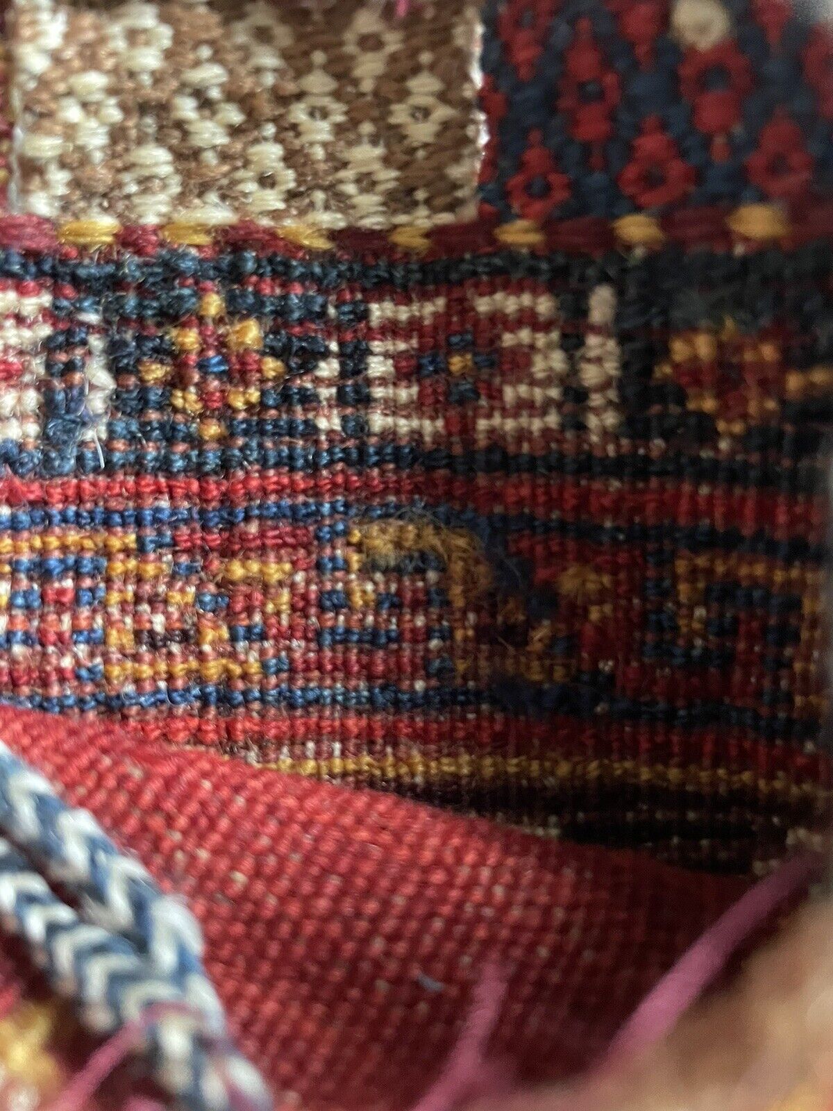 The handmade antique Persian Gashkai small bag (1900s) displayed on a shelf with other collectible items.
