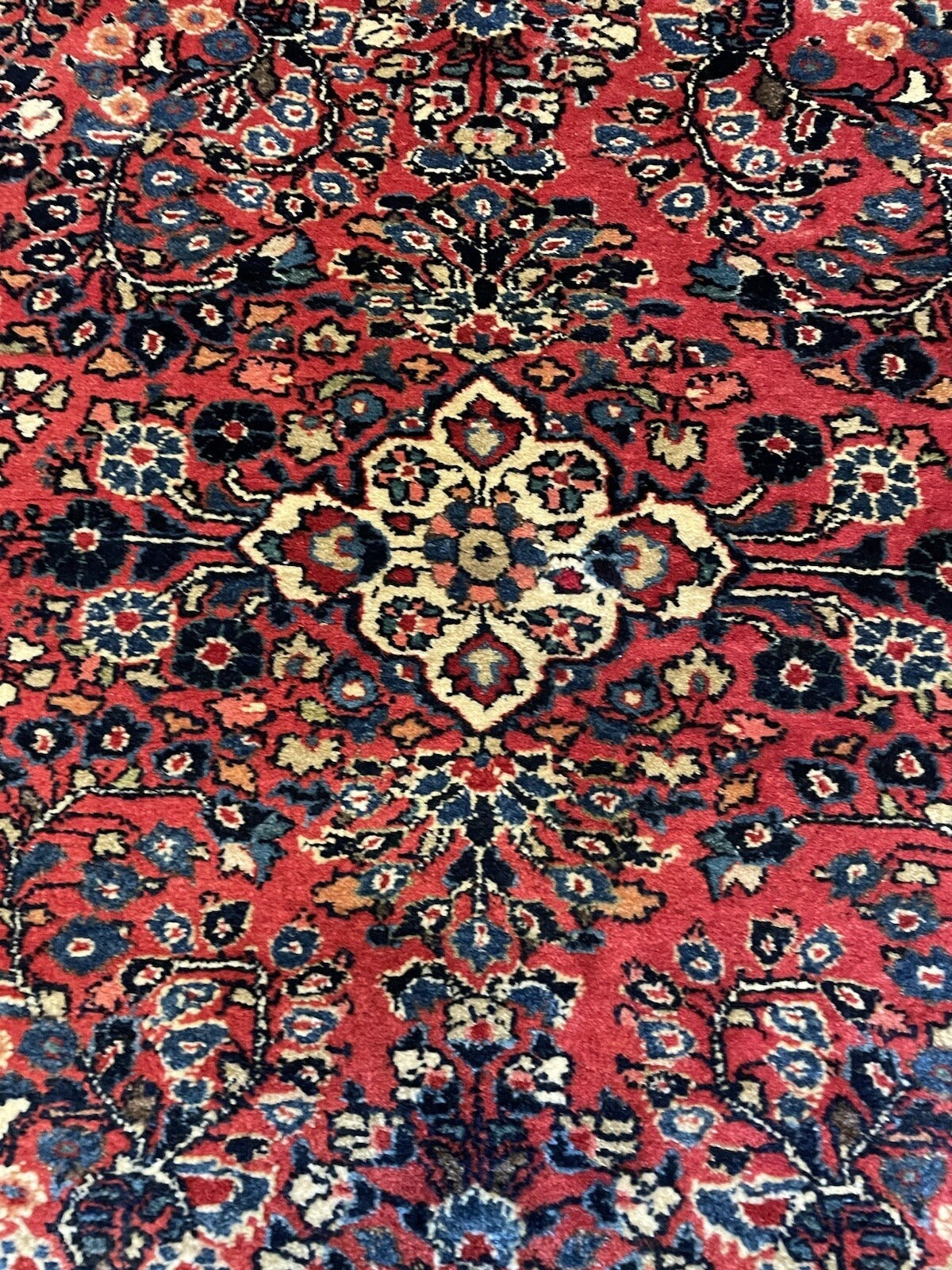 Antique Middle Eastern Sarouk rug with natural patina from gentle aging, dense hand-spun wool pile, and intact natural ivory fringe at both ends.

