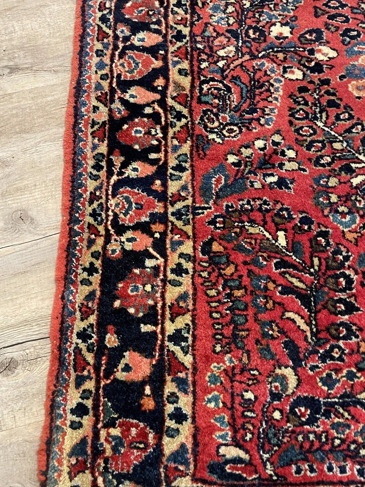 Hand-knotted 1920s Sarouk rug with an elaborate eight-pointed star medallion in ivory and navy, surrounded by unique floral rosettes in rose and gold.

