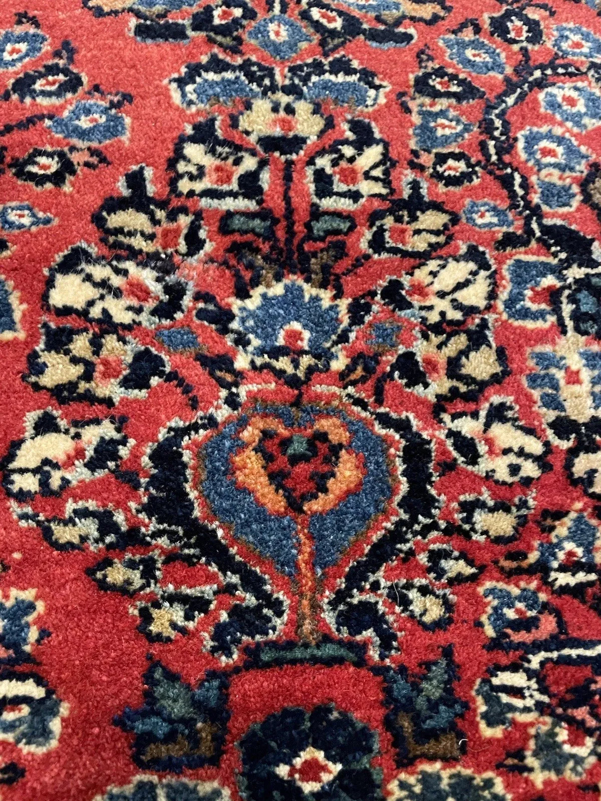 Traditional Sarouk wool rug with a balanced allover botanical pattern, deep crimson field, and warm amber accents, ideal for a study or sitting room.

