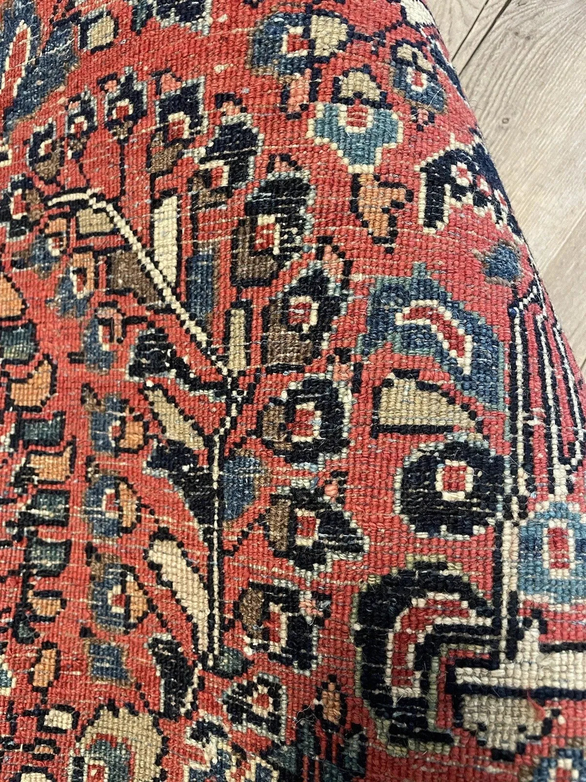 Decorative 1920s Sarouk rug displayed flat, highlighting its dense floral sprays, each uniquely woven, creating a garden-like abundance.

