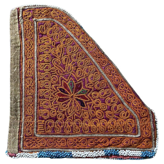 Close-up view of a handmade antique Uzbek Suzani collectible bag (1920s) featuring vibrant floral and geometric embroidery in red, gold, and purple.