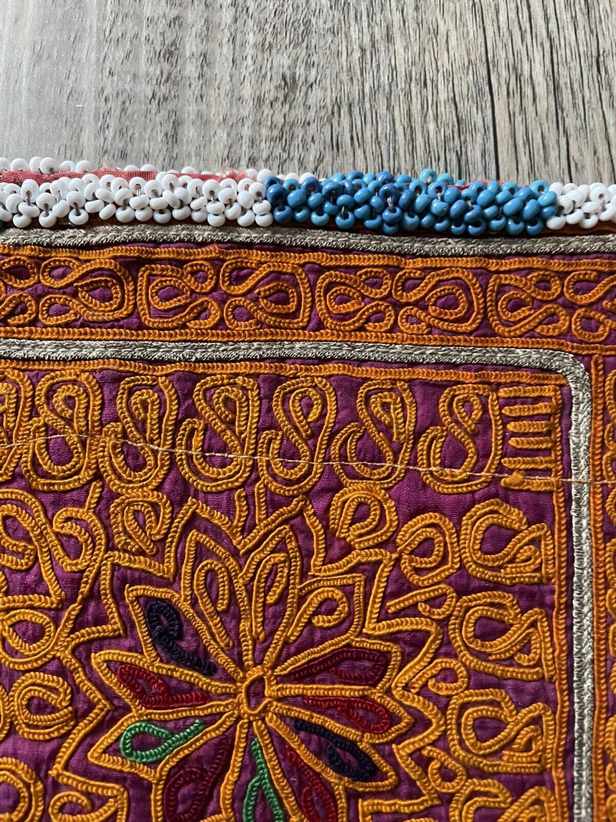 The handmade antique Uzbek Suzani collectible bag (1920s) alongside a map of Uzbekistan, highlighting its origin.