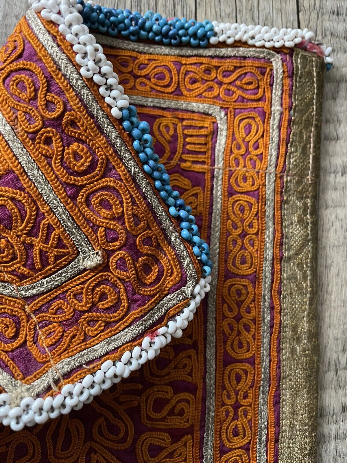 The handmade antique Uzbek Suzani collectible bag (1920s) displayed in natural light, showcasing the vibrancy of the colors.