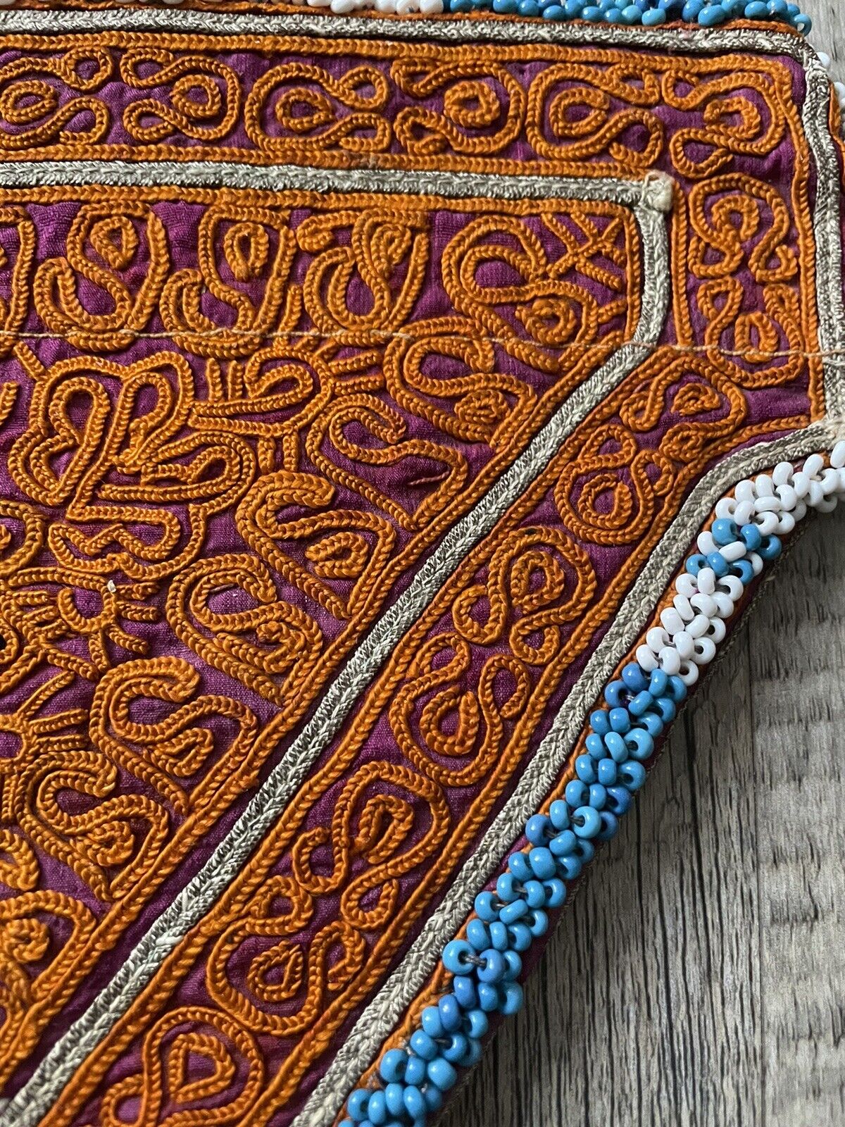 The handmade antique Uzbek Suzani collectible bag (1920s) displayed with other antique textiles.