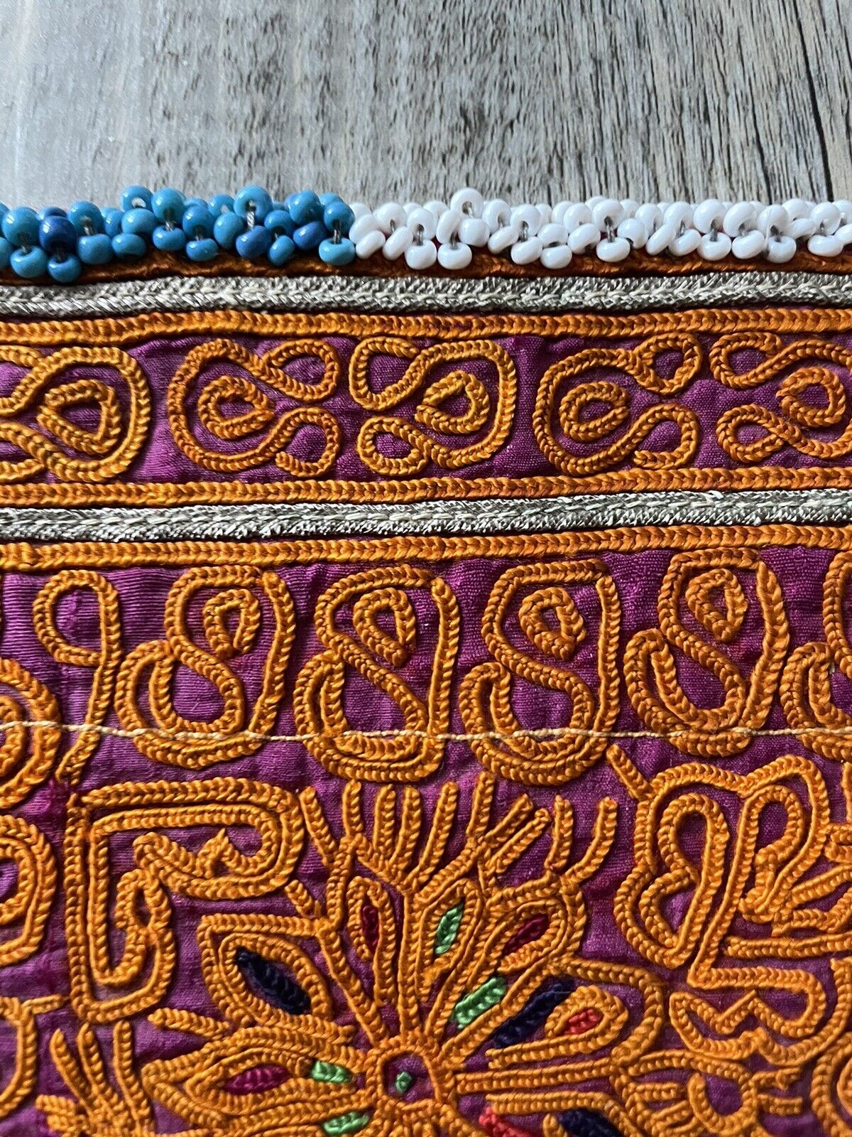Close-up of the rich purple accents in the embroidery of a handmade antique Uzbek Suzani collectible bag (1920s).