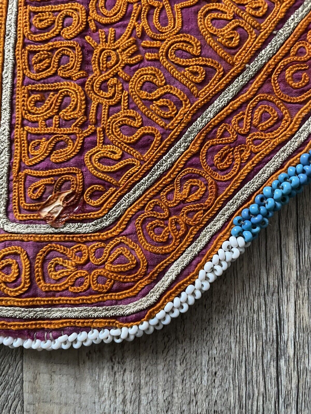 The handmade antique Uzbek Suzani collectible bag (1920s) held in hand, showcasing its size and versatility.