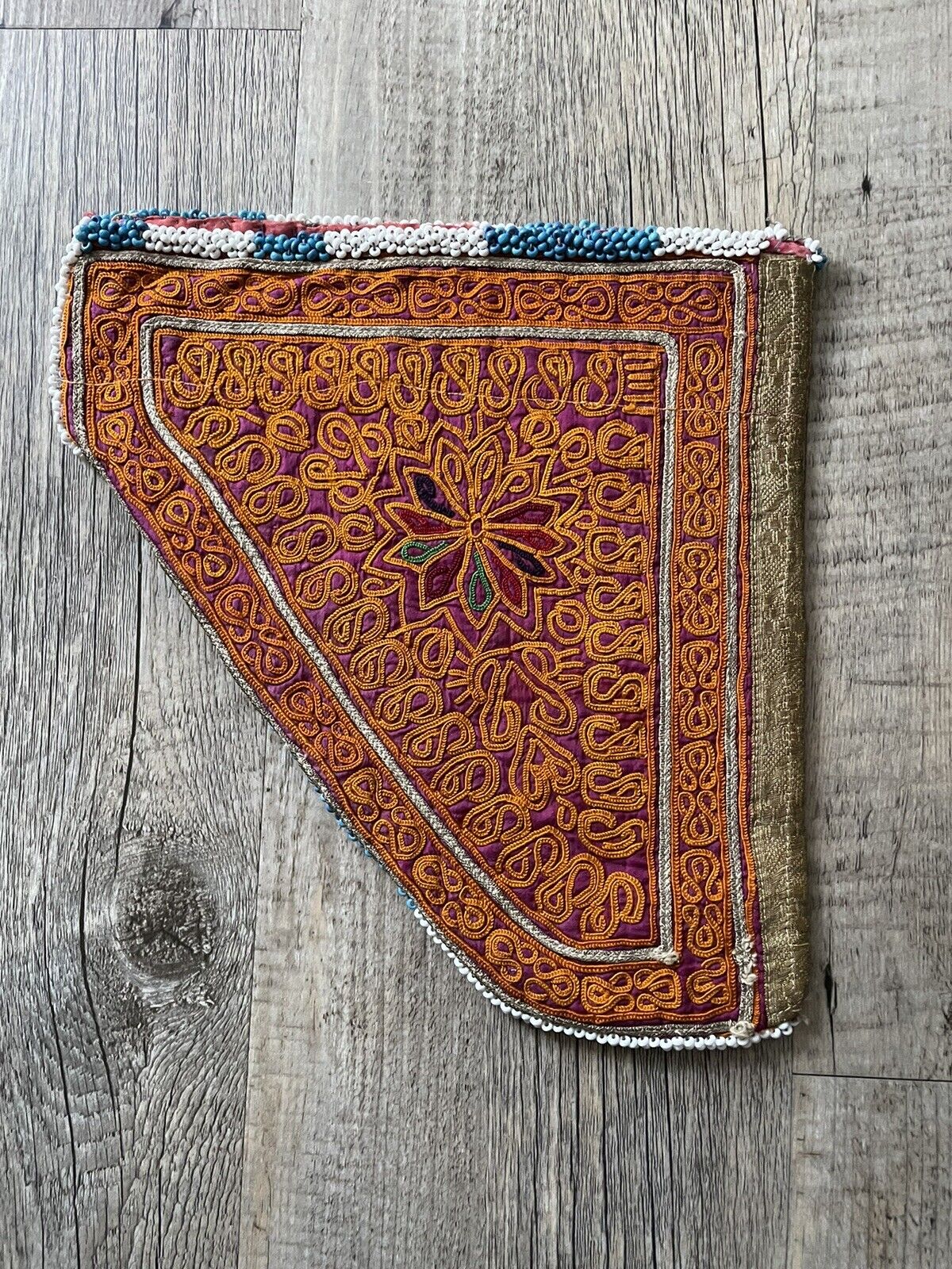 The handmade antique Uzbek Suzani collectible bag (1920s) styled with bohemian clothing.