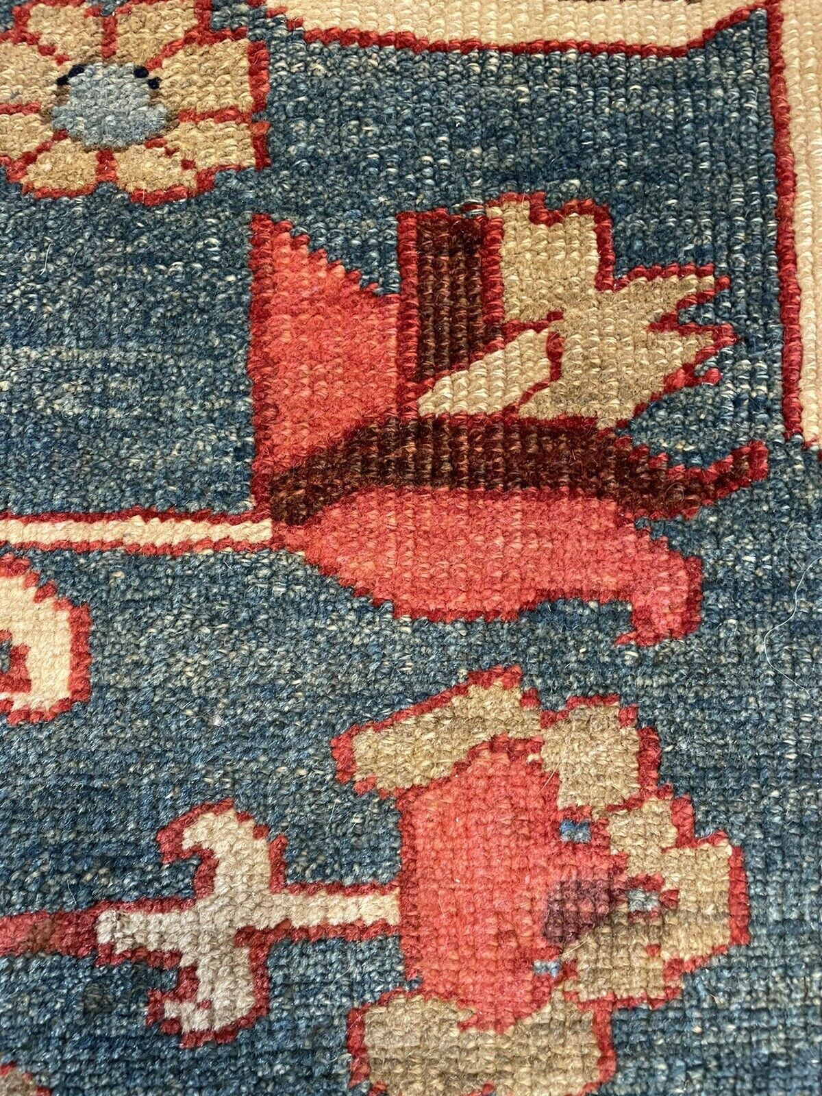A detail of the rug's signature on the back (if present), potentially revealing the weaving workshop or artist from the Heriz region.
