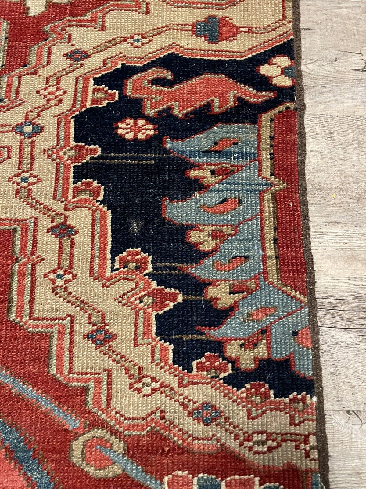 Close-up of a single boteh motif within the rug's design, showcasing the detailed craftsmanship and use of natural dyes to achieve the rich red hue.