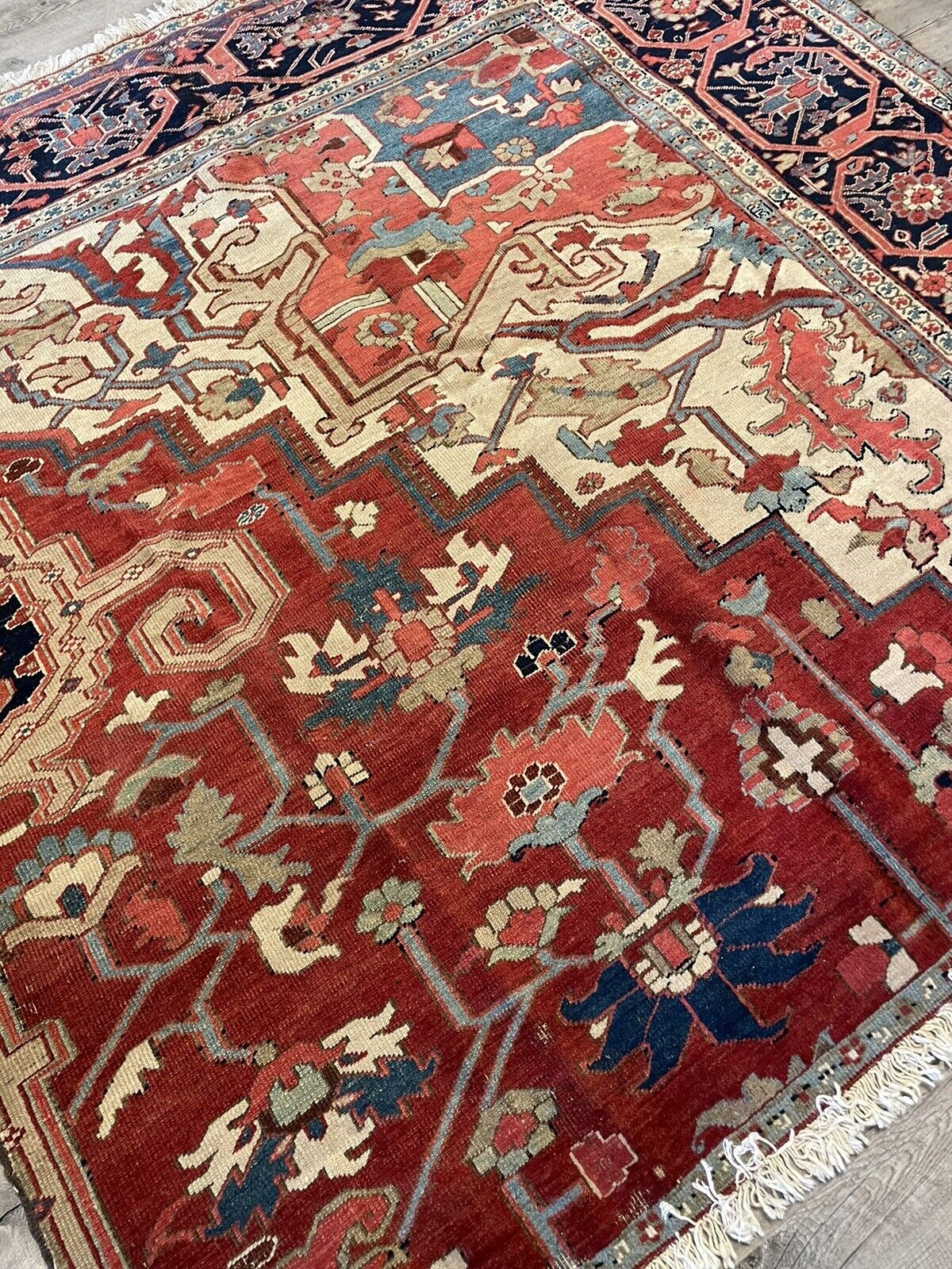 The rug displayed on a map of Persia (Iran), highlighting its origin and connection to the Heriz region's weaving traditions.