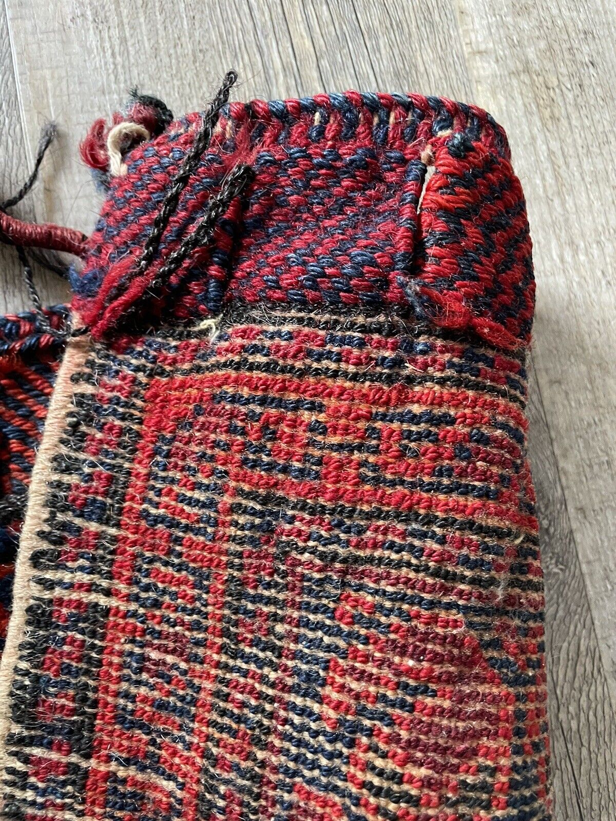 The backside of a handwoven antique Persian Shiraz bagface (1900s), revealing the natural wool fibers and the hand-knotted construction techniques used in its creation.