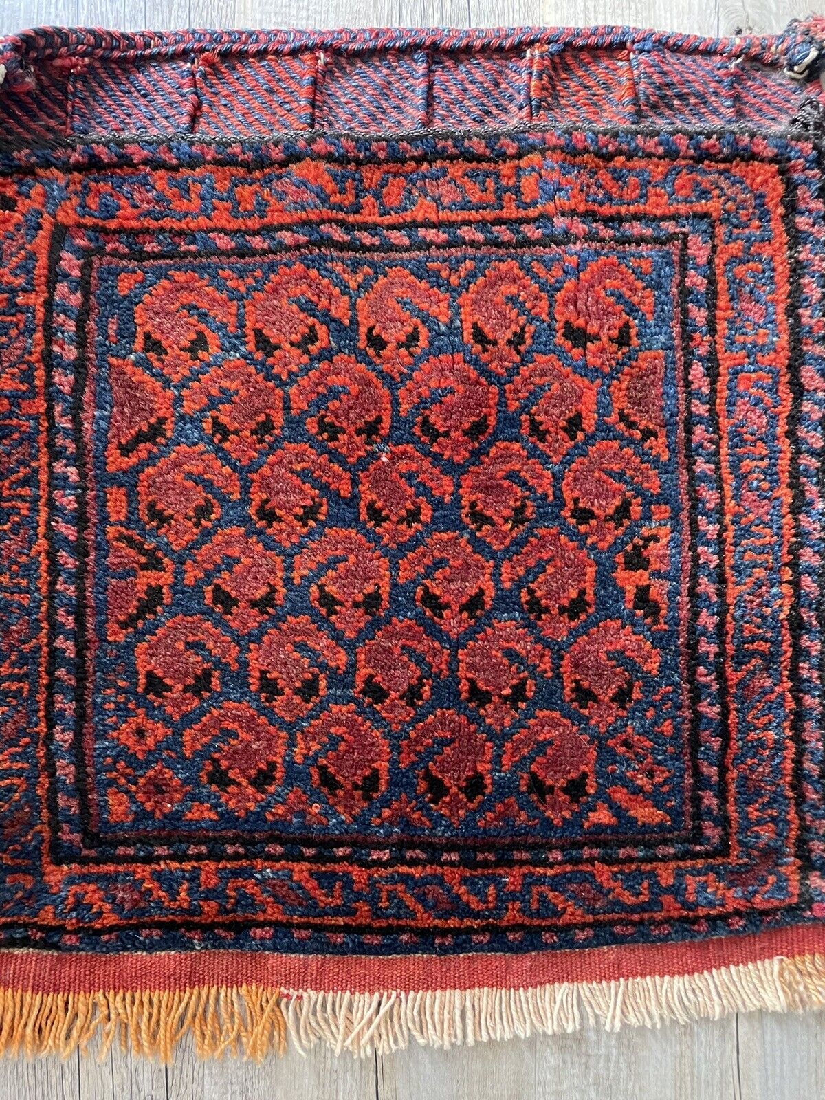 Detailed Pattern: A close-up of the central medallion on the Shiraz bagface (1900s), highlighting the use of various colored wools and intricate knotting techniques to create a captivating design.