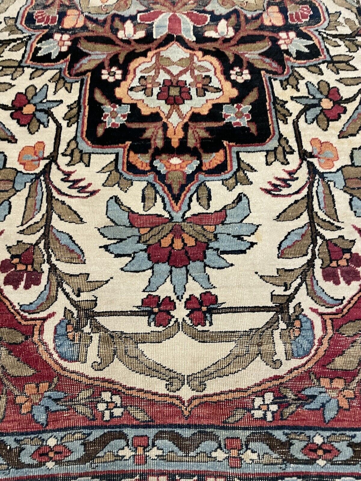 Close-up of antique Kerman Lavar rug’s detailed medallion design
