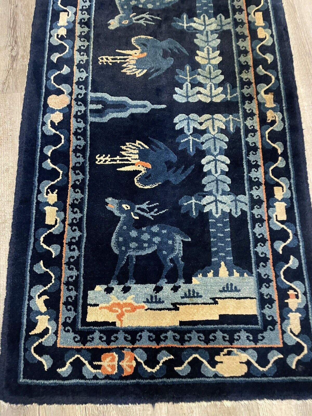 Handwoven antique Peking rug featuring elegant wildlife designs
