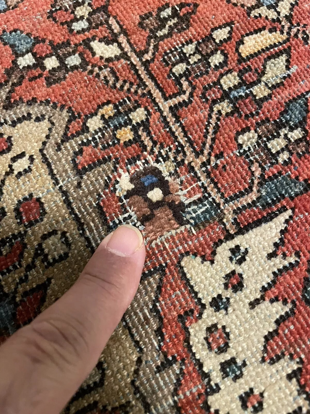 Distressed vintage Persian rug with intricate floral and geometric motifs
