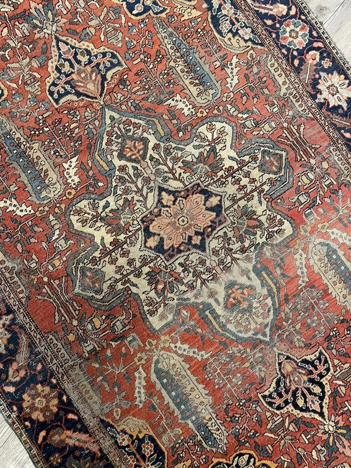 Close-up of Persian rug’s intricate patterns and aged texture

