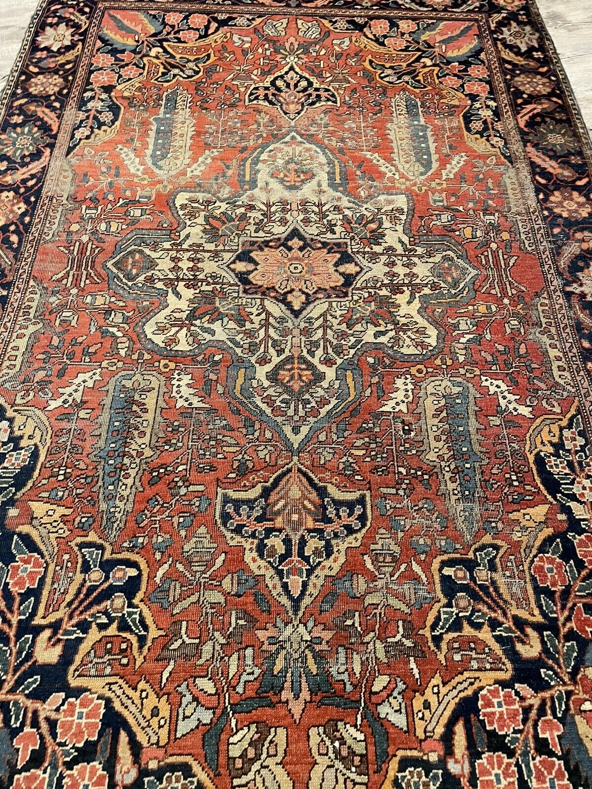 Authentic Persian wool rug with visible signs of historical wear

