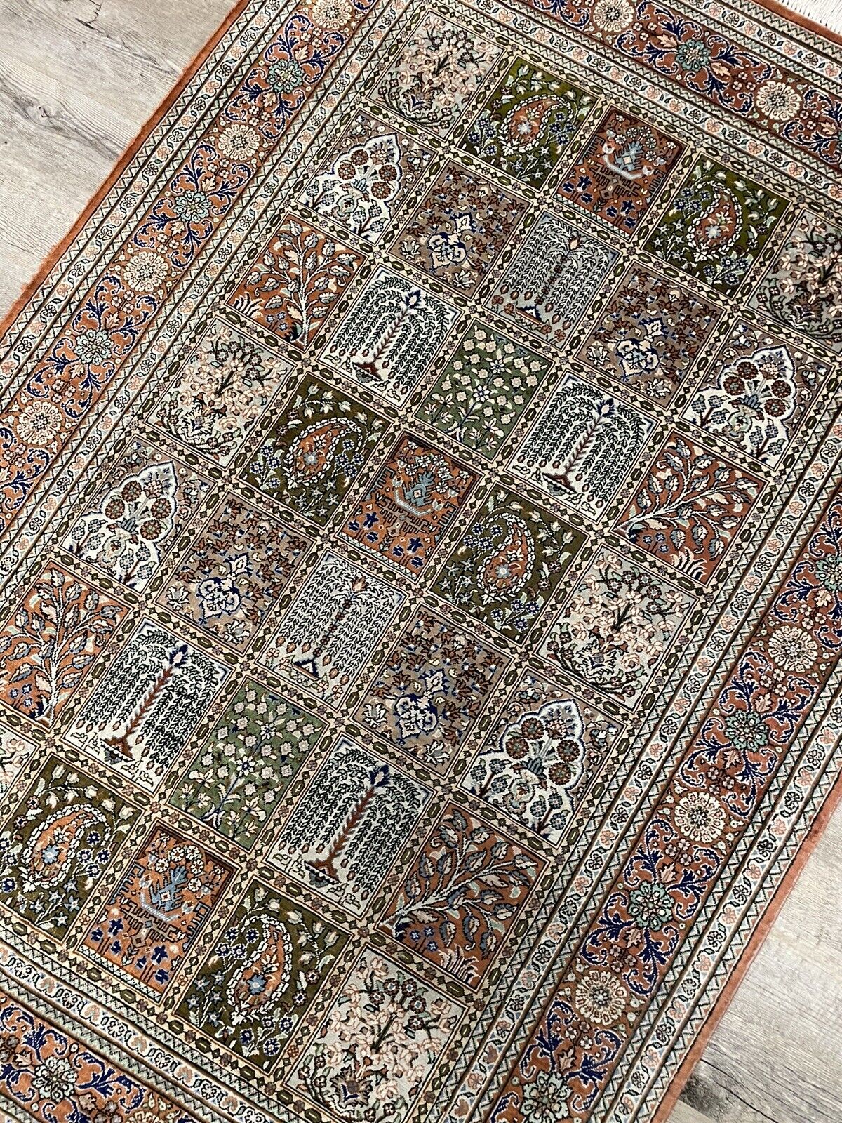 Green, brown, and blue silk Persian rug with elegant design
