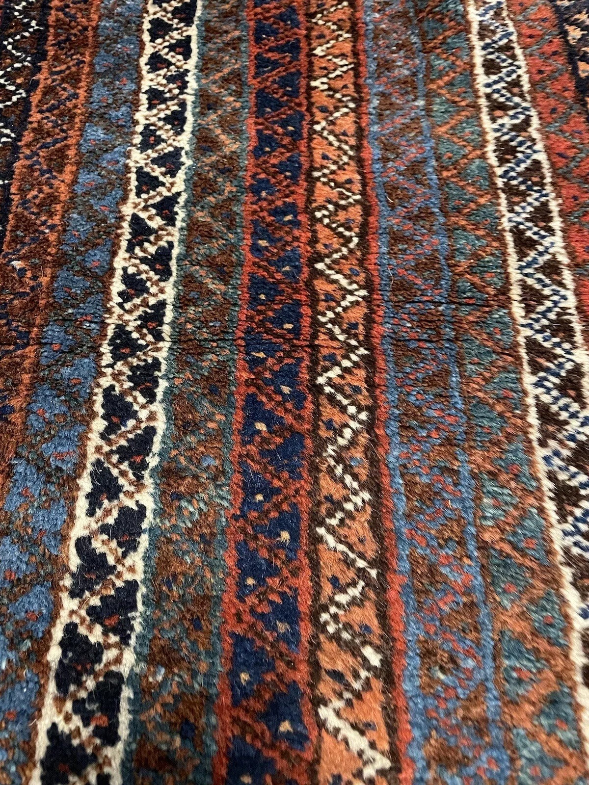 Antique Persian rug with traditional motifs and floral details
