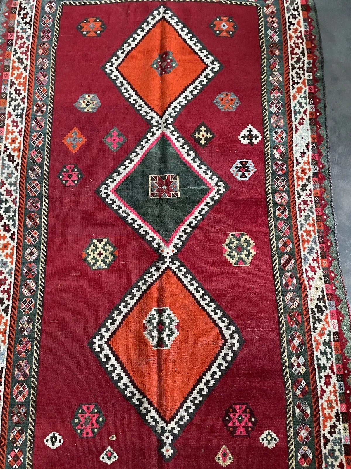 Geometric diamond motifs on a Persian Gabbeh rug with red and multicolored details

