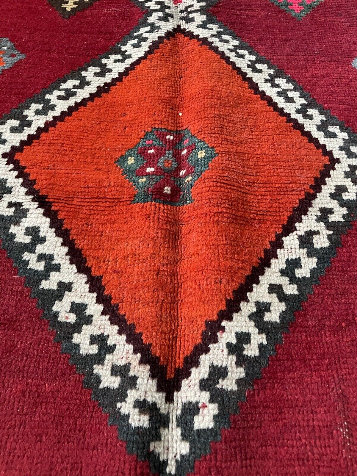 Bold and colorful Persian tribal rug with intricate border details
