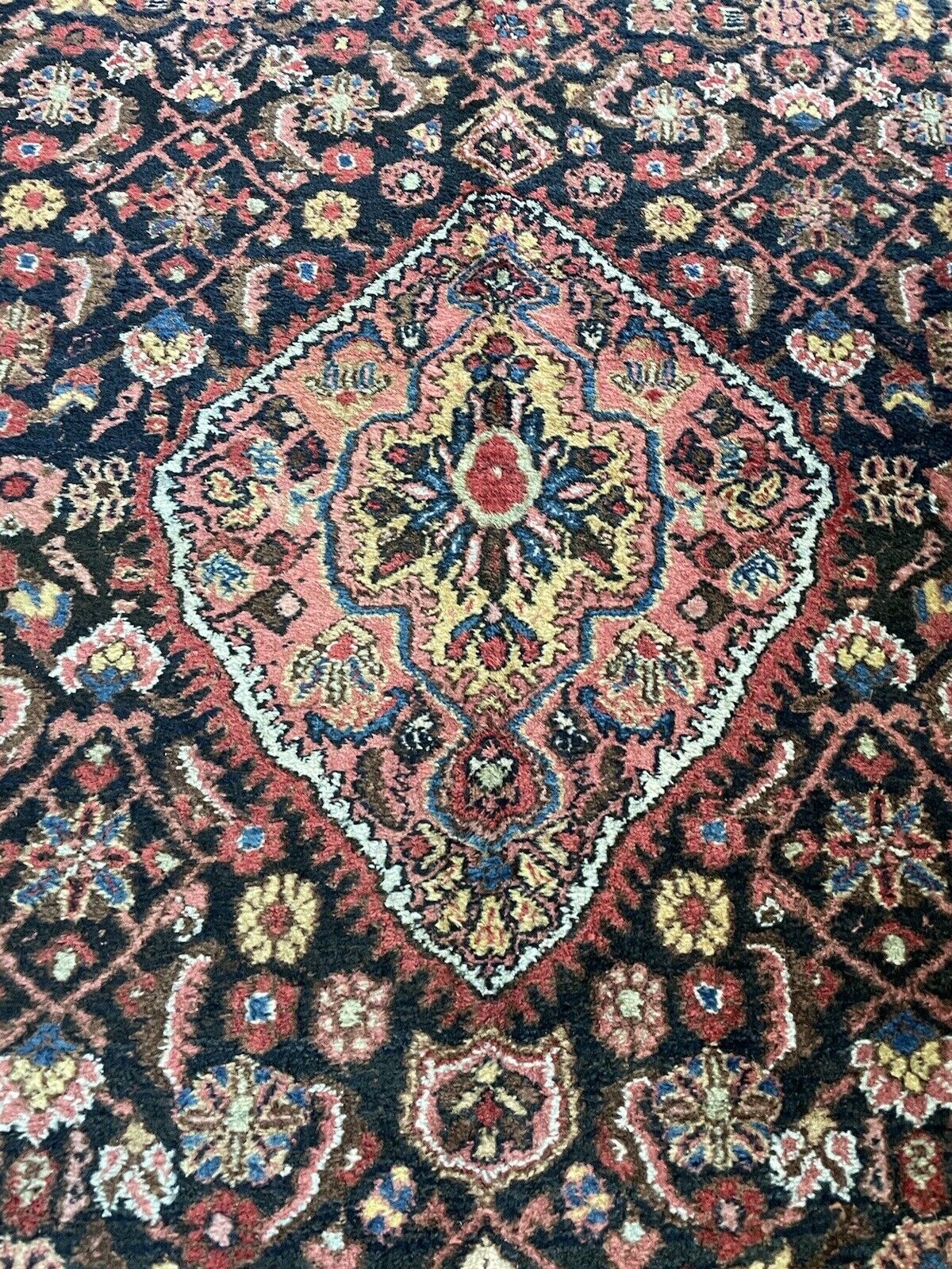 Deep red, blue, and beige tones in an antique Persian Bidjar rug
