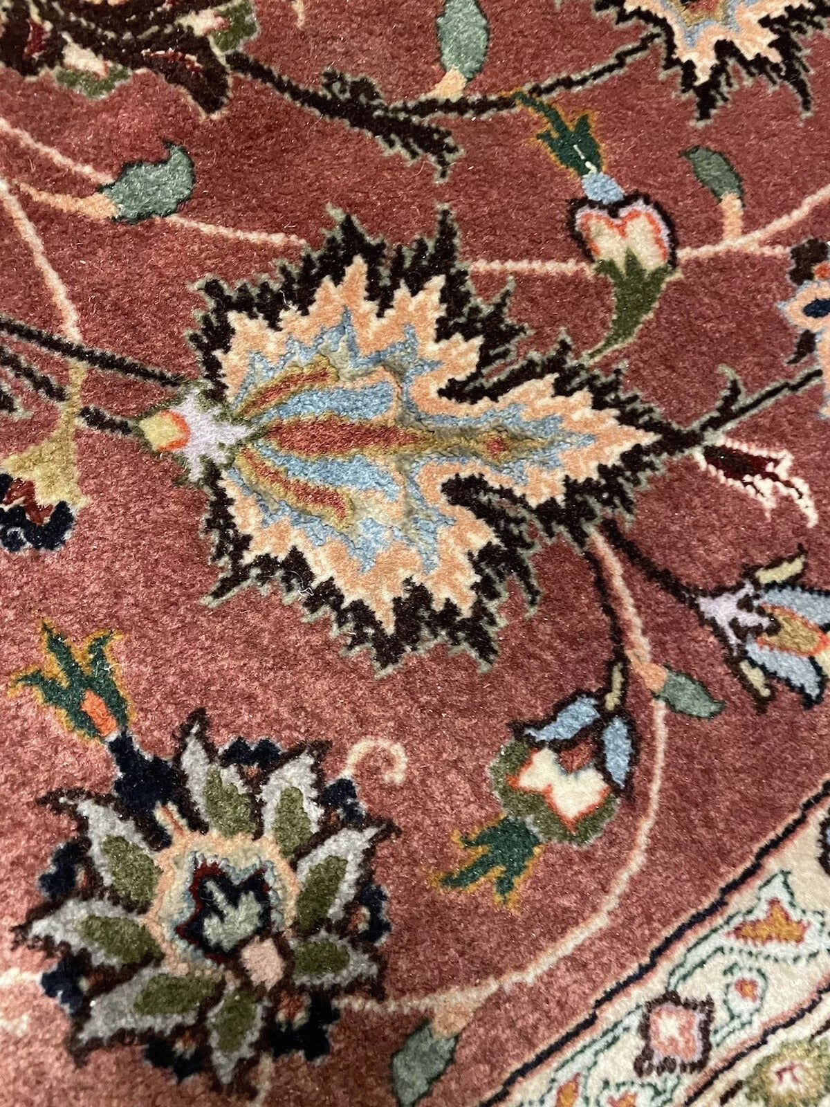 Round Persian rug with traditional motifs and luxurious materials
