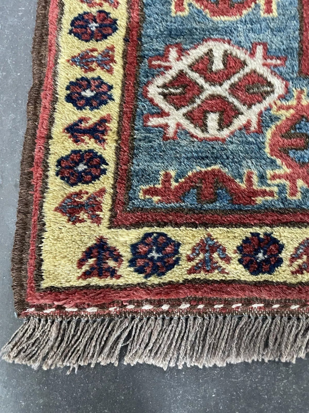 Close-up of geometric motifs on a vintage Kazak rug

