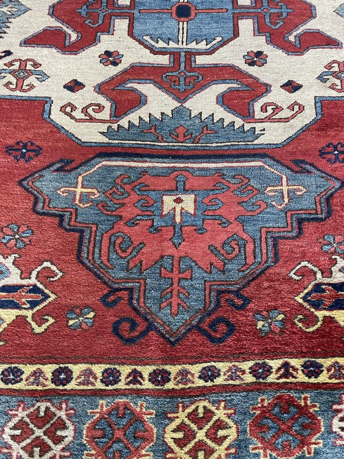 Handmade Kazak wool rug with intricate geometric designs
