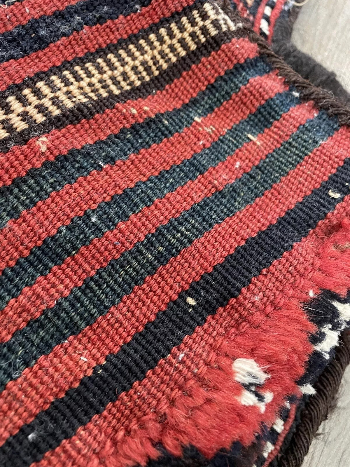 Handwoven Persian Sumak salt bag, vibrant red and black hues
