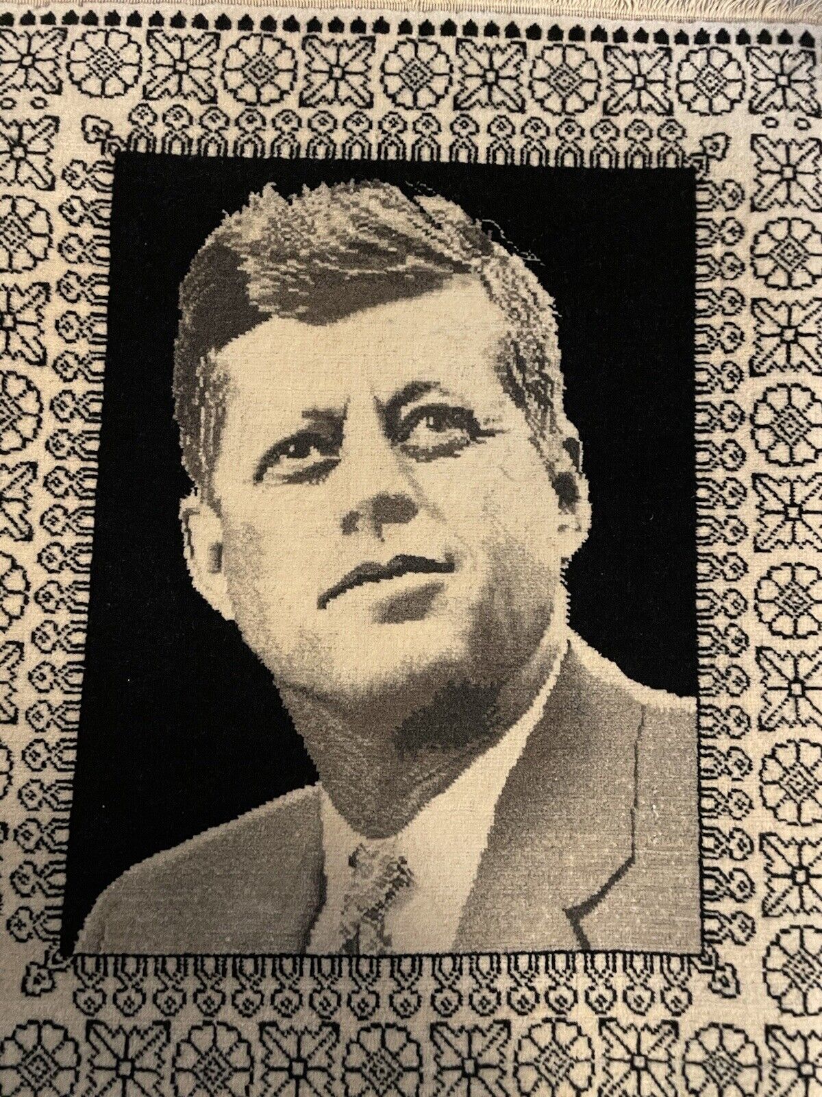 Intricate border patterns and fringe of a Tabriz rug with JFK portrait
