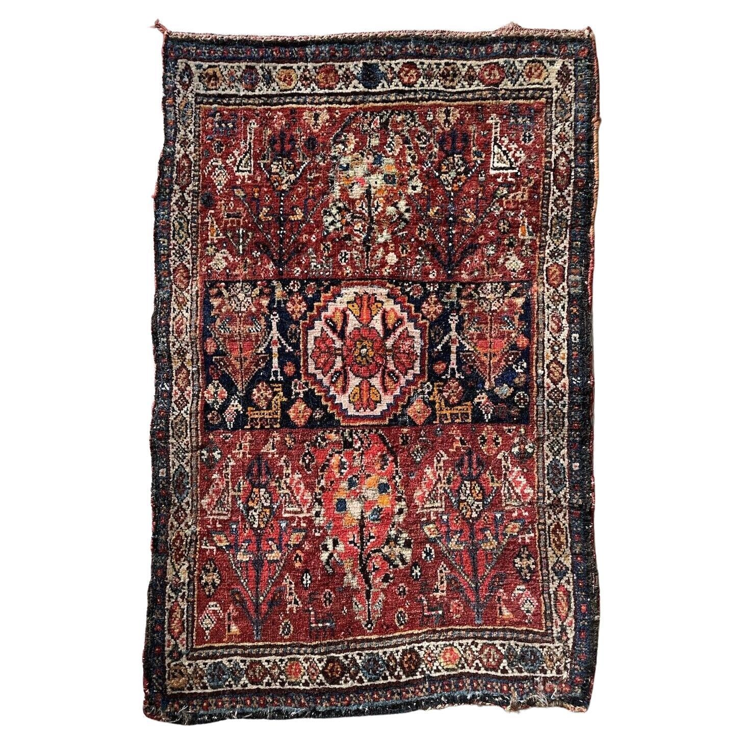 Close-up of intricate floral motifs on an antique Gashkai rug
