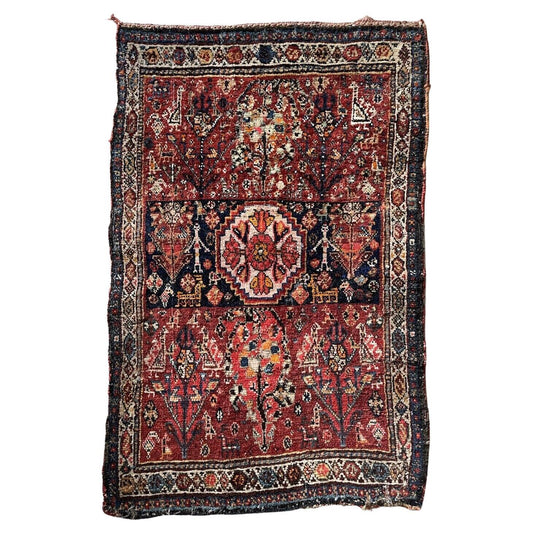 Close-up of intricate floral motifs on an antique Gashkai rug
