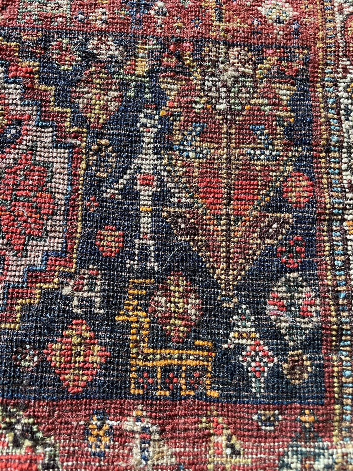 Handmade Gashkai rug with geometric border patterns
