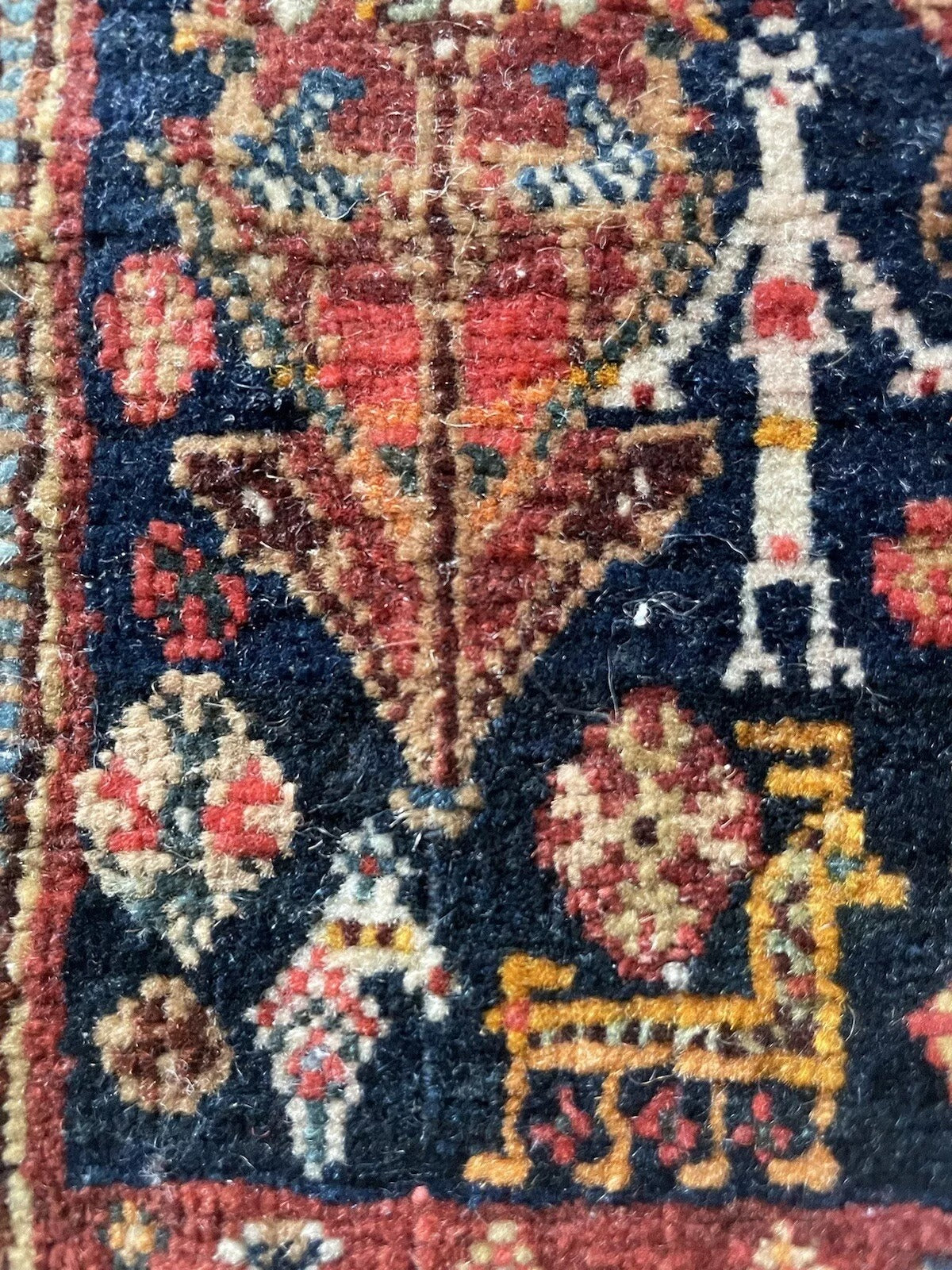 Close-up of hand-knotted wool detailing on a Gashkai rug
