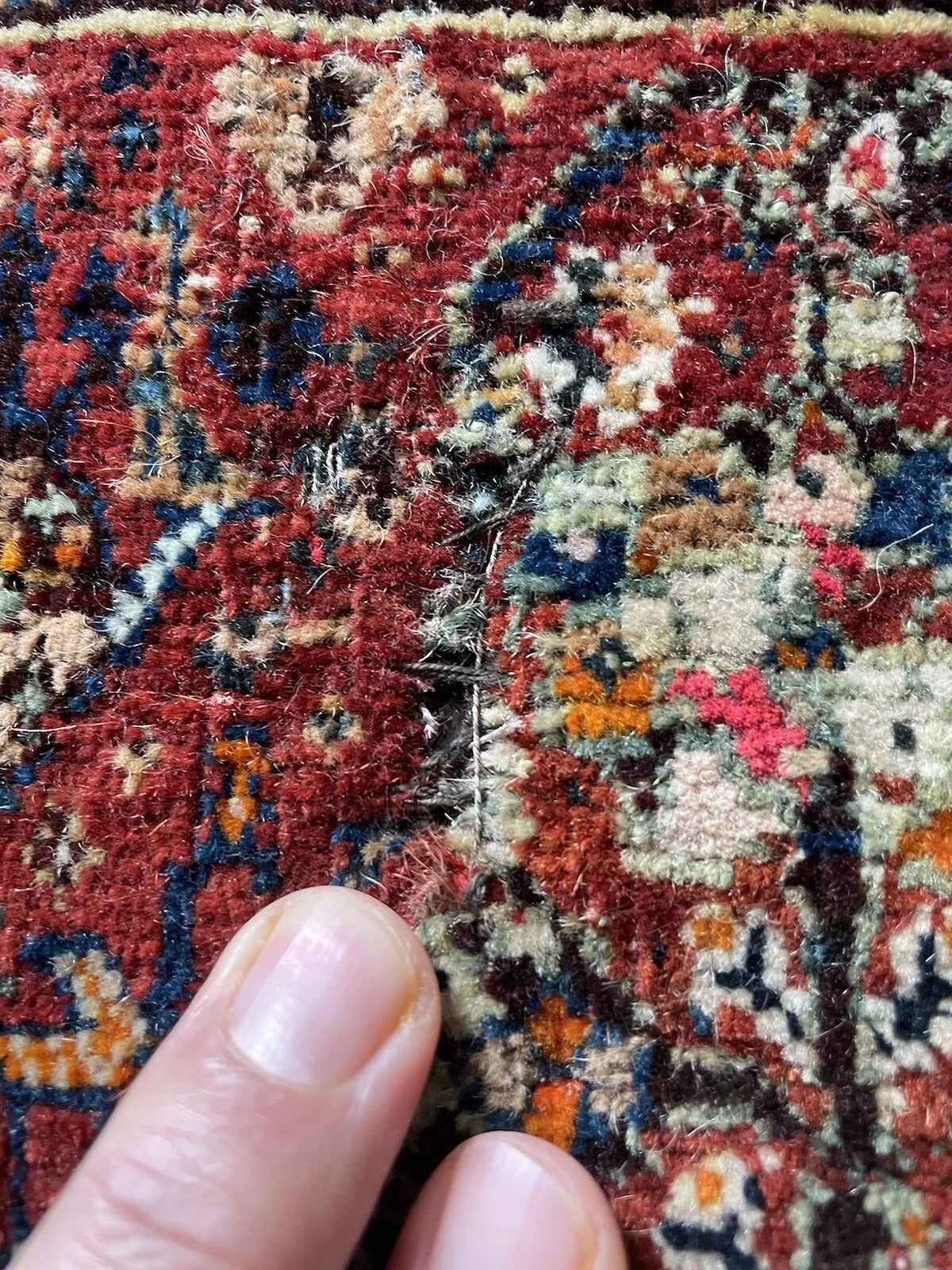 Antique Gashkai rug with visible age wear and patina
