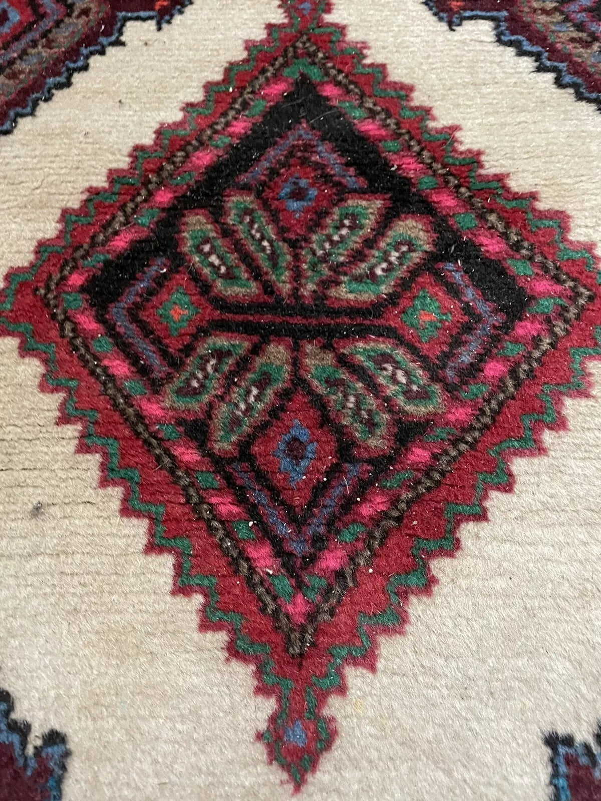Rich red, brown, and cream colors on a Hamadan wool rug

