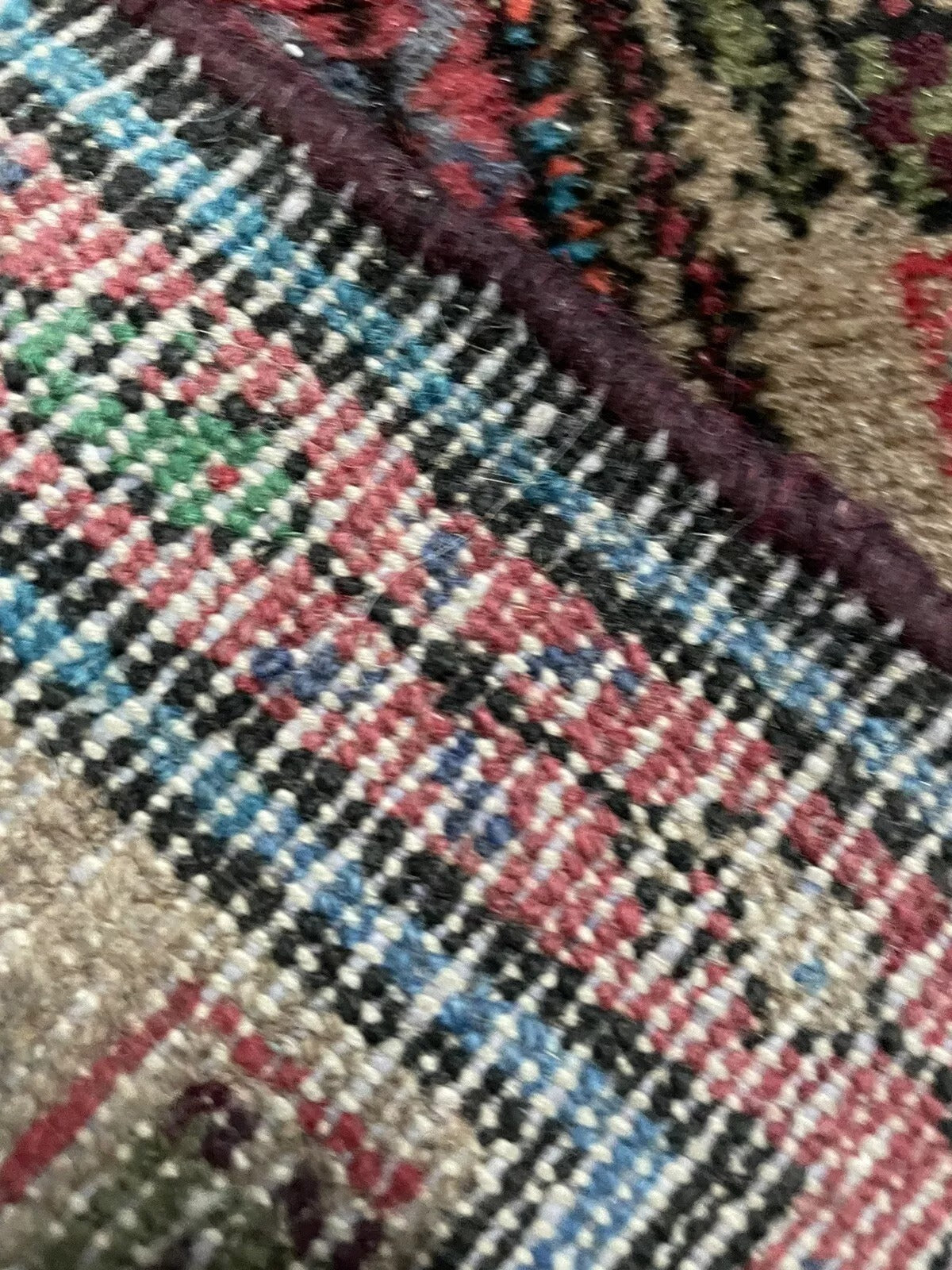 Close-up of wool texture and fringe on a Hamadan runner rug
