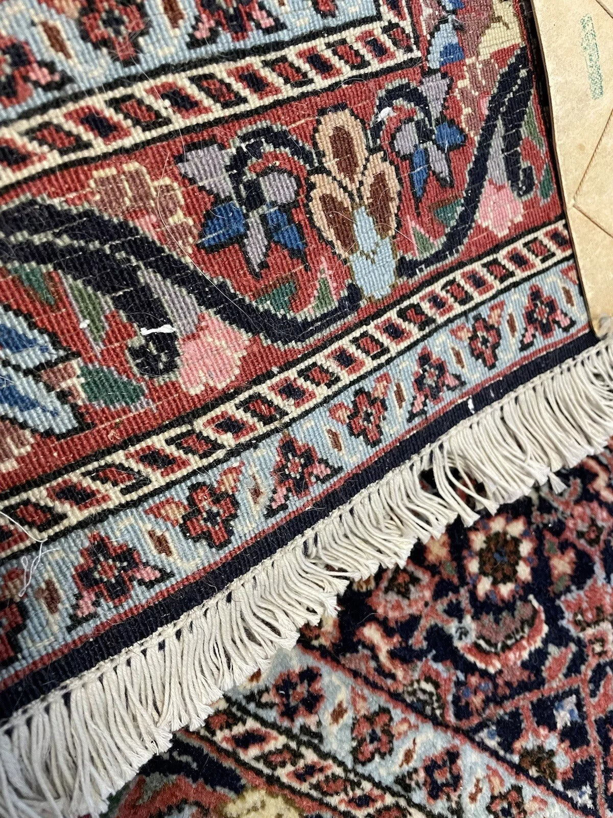 Close-up of the detailed floral motifs on a vintage wool rug
