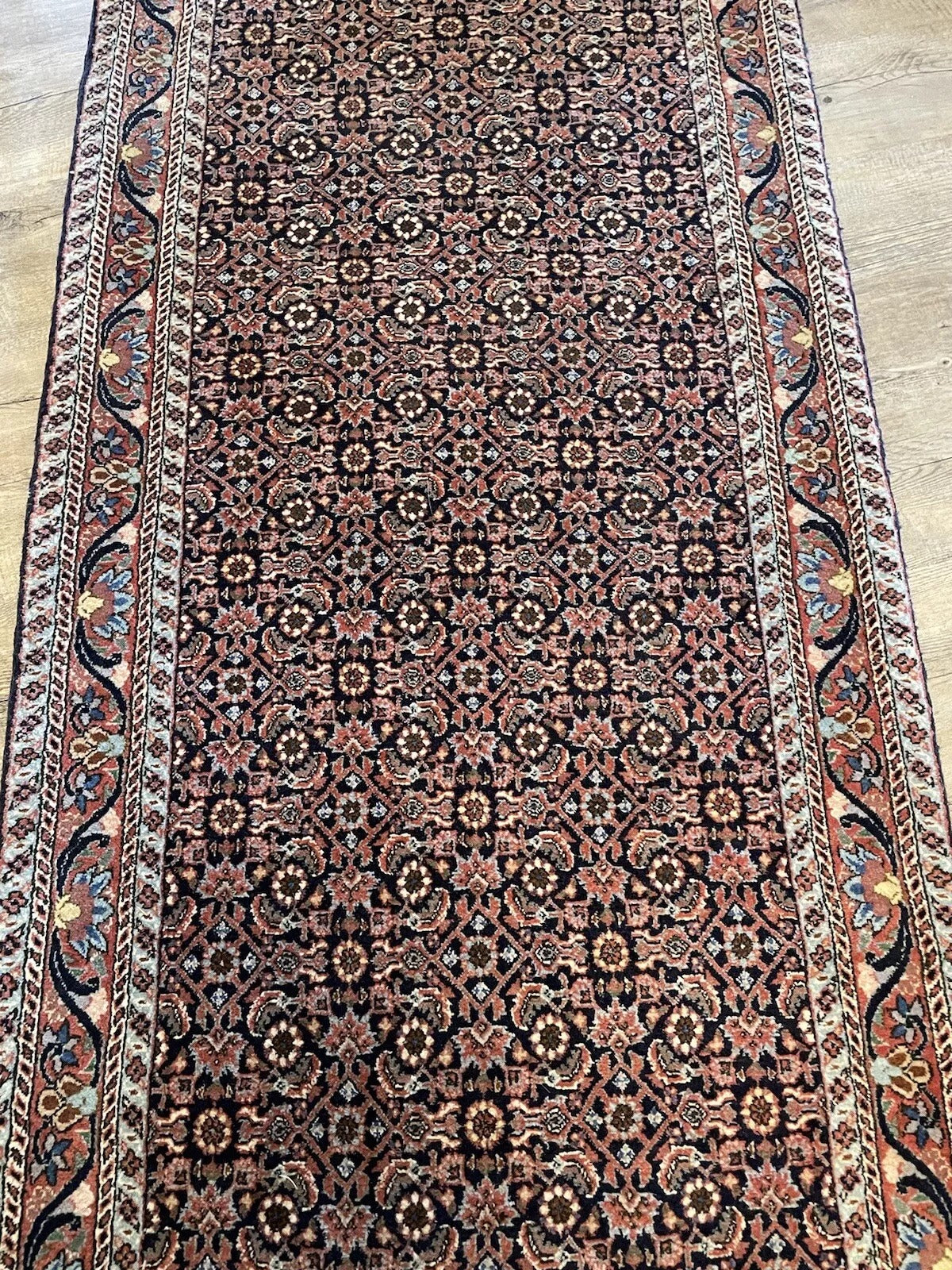 Hallway runner rug with dense wool texture and classic Persian-style design
