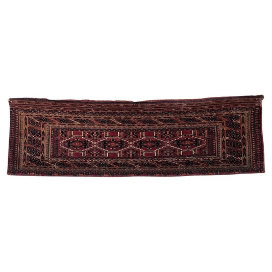 Close-up of antique Turkmen Yomud rug with intricate red and black patterns
