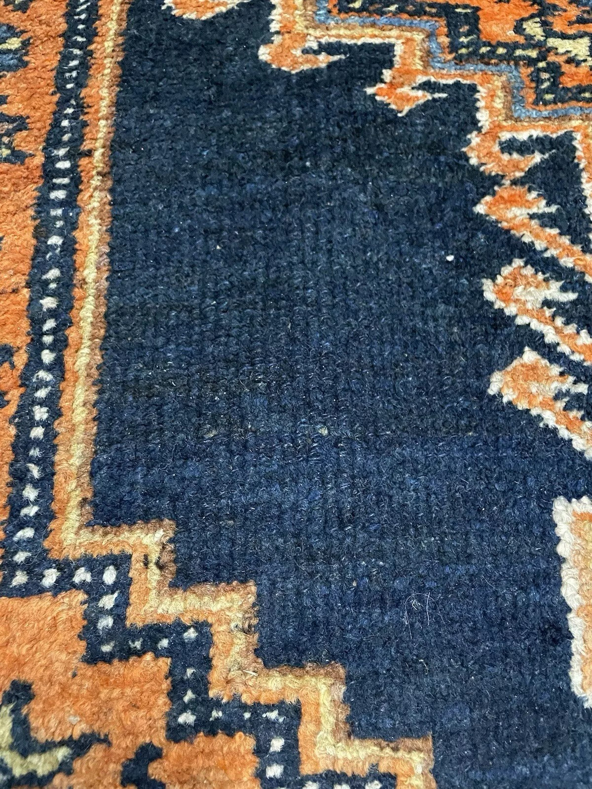 Close-up of geometric and floral motifs in a Persian Hamadan rug
