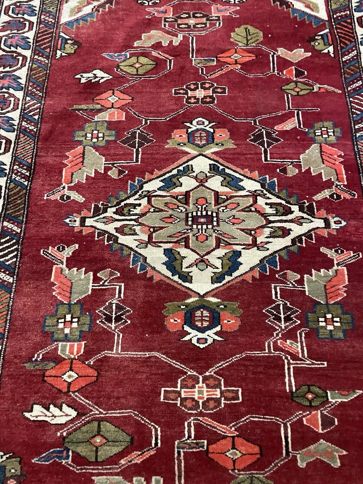 1970s Persian wool rug with deep red, blue, and white tones.

