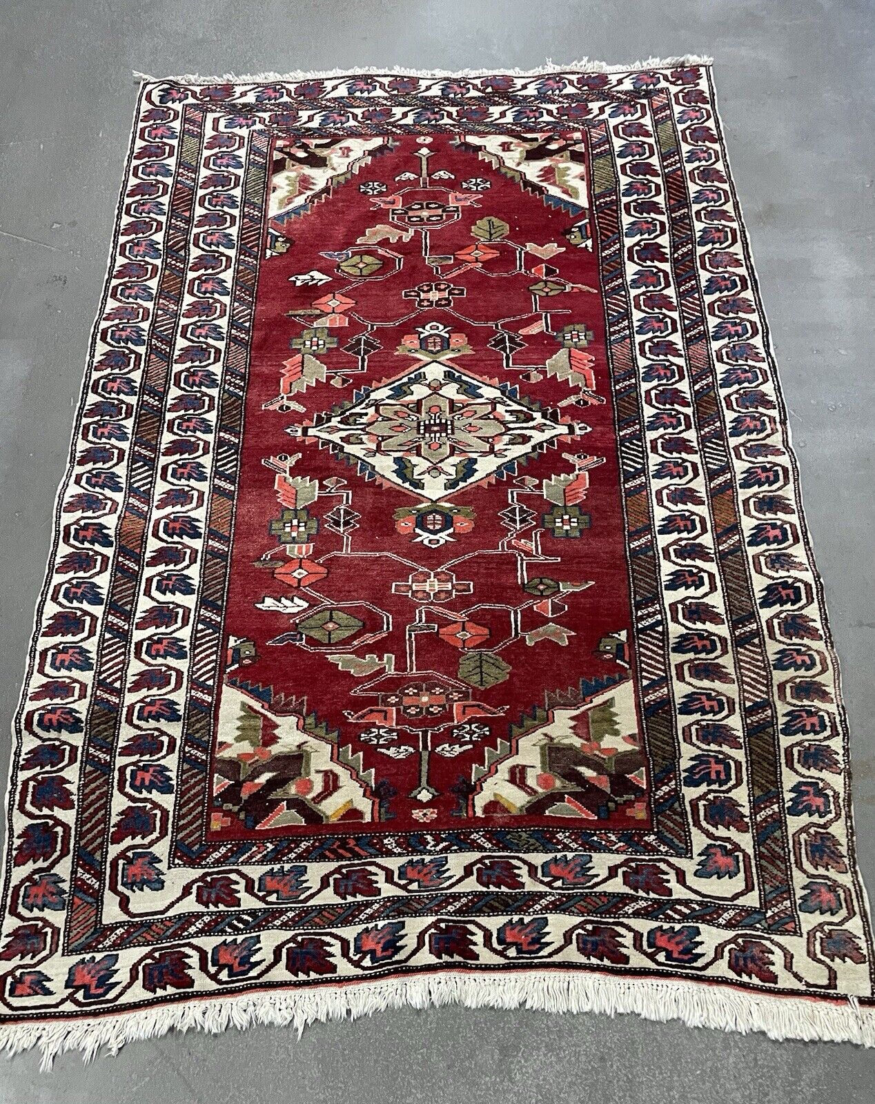 Handmade vintage Persian rug with bold red background.

